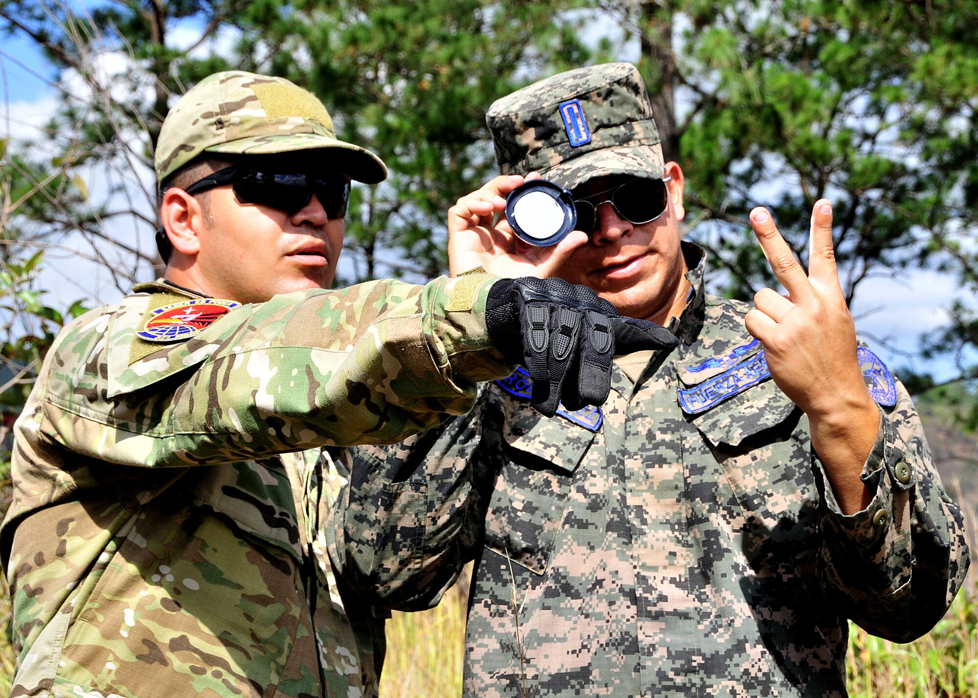Tech. Sgt. Filiberto Rodriguez, 571st Mobility Support Advisory Squadron fuels air advisor, explains to a Honduran Air Force pilot how to signal with a mirror during the field application of the aircrew survival seminar at Tamara, Honduras, Feb. 15.  (U.S. Air Force photo by Tech. Sgt. Lesley Waters)