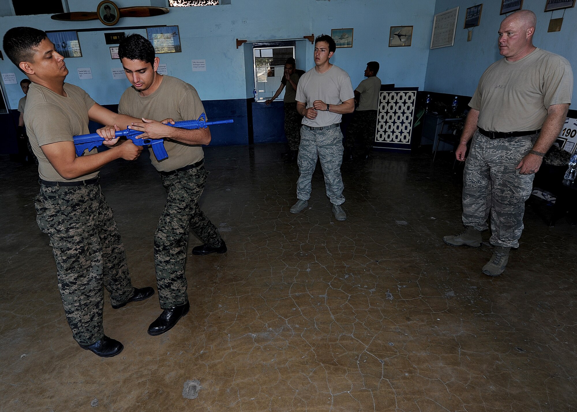 Master Sgt. Marc Slonecker and Staff Sgt. Alejandro Gutierrez, 571st Mobility Support Advisory Squadron security forces air advisors, observe 1st Lt. Ulises Aleman and 2nd Lt. Manuel Sosa, Honduran Air Force security forces members, conduct rifle disarm as part of the self-protection portion of the air base defense seminar Feb. 14, during the Air Mobility Command Building Partner Capacity mission in Tegucigalpa, Honduras.  (U.S. Air Force photo by Tech. Sgt. Lesley Waters)