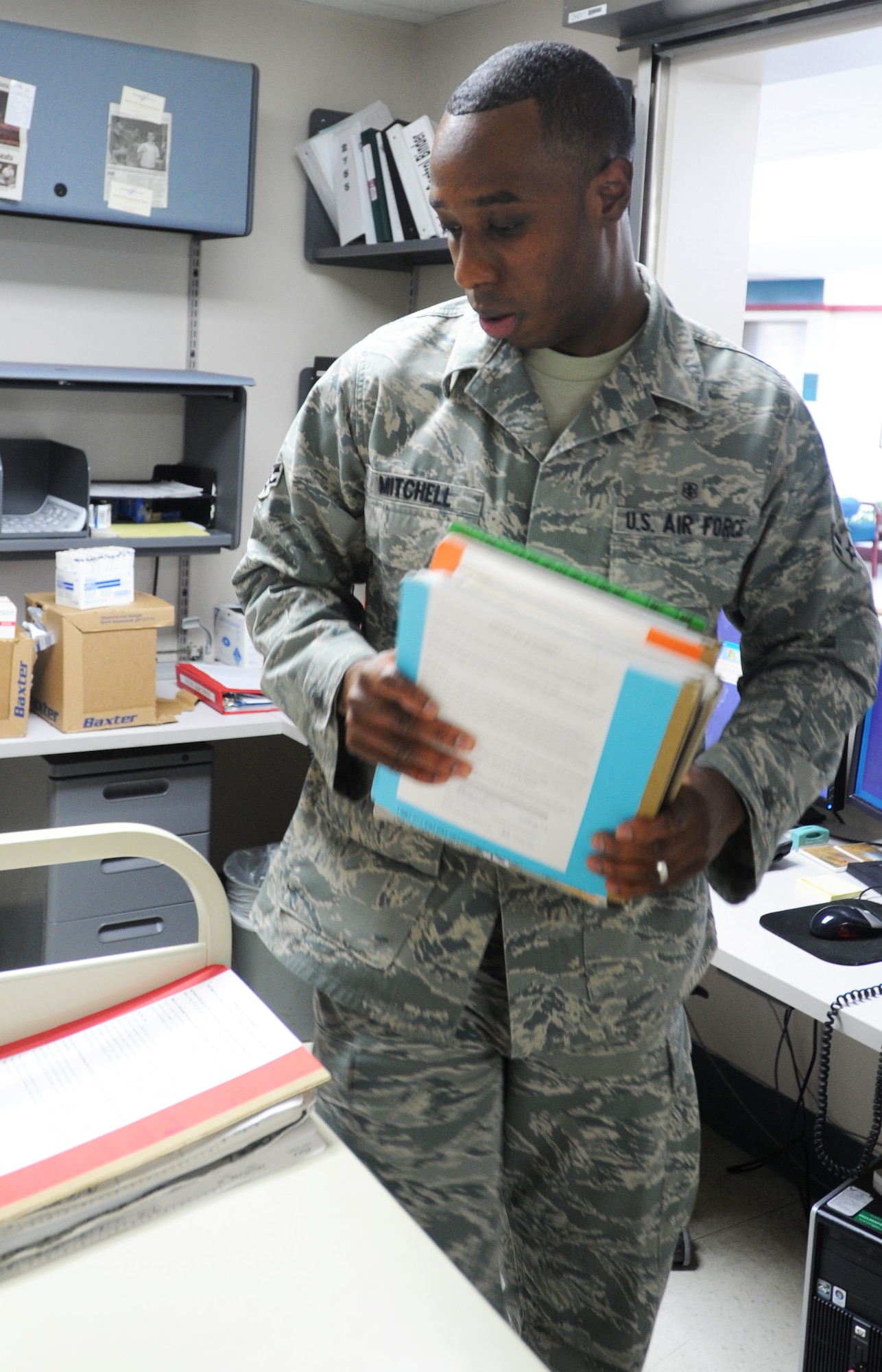 Airman 1st Class Michael Mitchell, 22nd Medical Support Squadron outpatient records technician, collects medical records from the patient in-processing desk Feb. 22, 2012, McConnell Air Force Base, Kan. As a records technician, Mitchell is responsible for preparing, updating and maintaining records. (U.S. Air Force photo/ Airman 1st Class Laura L. Valentine)