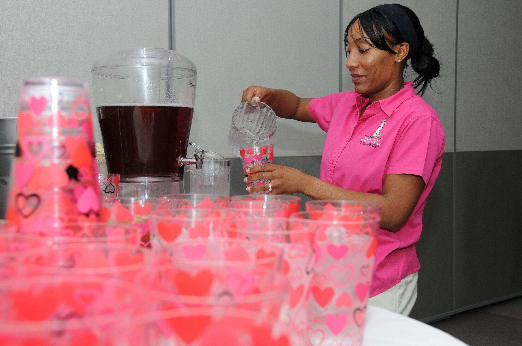 Tech. Sgt. Tomeika Washington, 81st Force Support Squadron, fills glasses for the attending members at the family night dinner for training students and their spouses Feb. 15, 2012, at the Levitow Training Support Facility, Keesler Air Force Base, Miss.  The meal was prepared by the airmen and family readiness center staff and served by members of the Key Spouse group, squadron commanders and first sergeants.  (U.S. Air Force photo by Kemberly Groue)