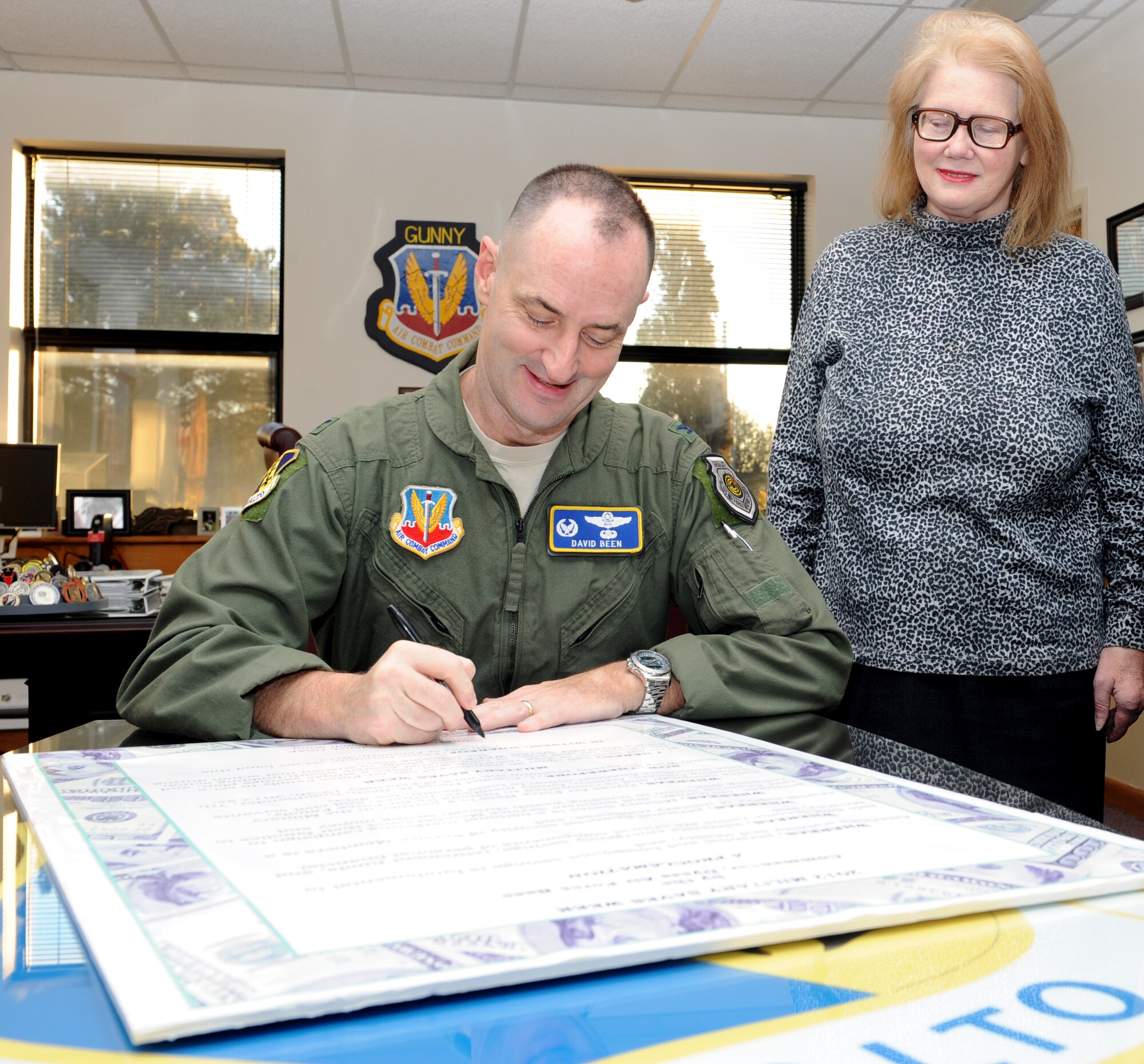 U.S. Air Force Col. David Been, 7th Bomb Wing commander, signs the Military Saves proclamation provided by Mrs. Margaret Naylor, 7th Force Support Squadron, Feb. 22, 2012, at Dyess Air Force Base, Texas. Military Saves is a social marketing campaign to persuade, motivate and encourage military families to save money every month and to convince leaders and organizations to be aggressive in promoting automatic savings. The Military Saves Financial Education Information Fair and Seminars is scheduled to be held from 8:00 a.m. to 4:00 p.m. at the Heritage Club on Feb. 24, 2012.  (U.S. Air Force photo by Airman 1st Class Jonathan Stefanko/ Released)