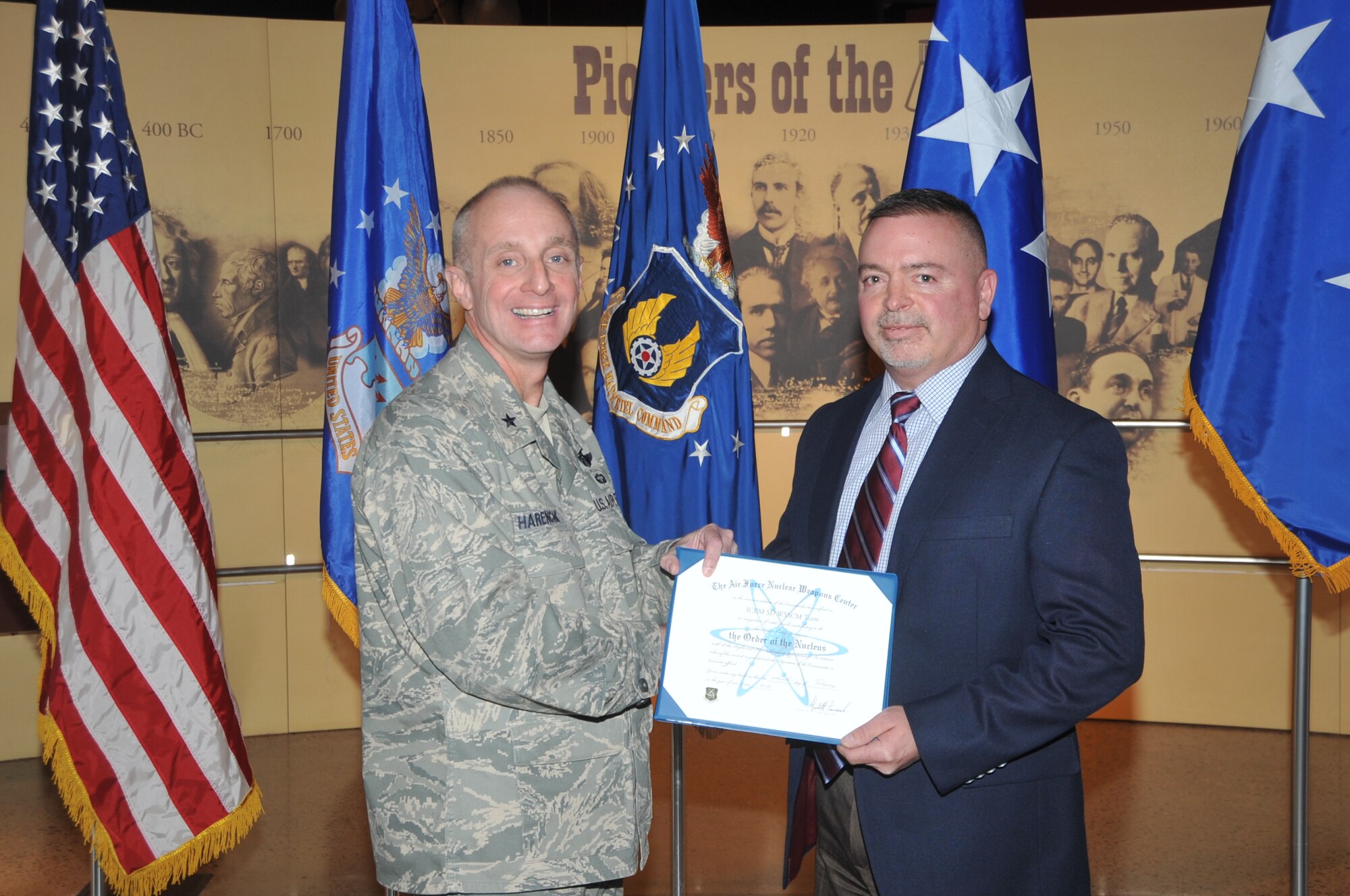 KIRTLAND AFB, N.M. -- Brig. Gen. Garrett Harencak, commander of the Air Force Nuclear Weapons Center, left, presents the ‘Order of the Nucleus’ to Dave Lorenz, who accepted it on behalf of the Weapons Center Systems Supply Chain Management Team from the ICBM Directorate, on Feb. 16 at the National Museum of Nuclear Science & History. The award is presented to those who are supporting and have supported the nuclear enterprise with great distinction. (Photo by Todd Berenger)