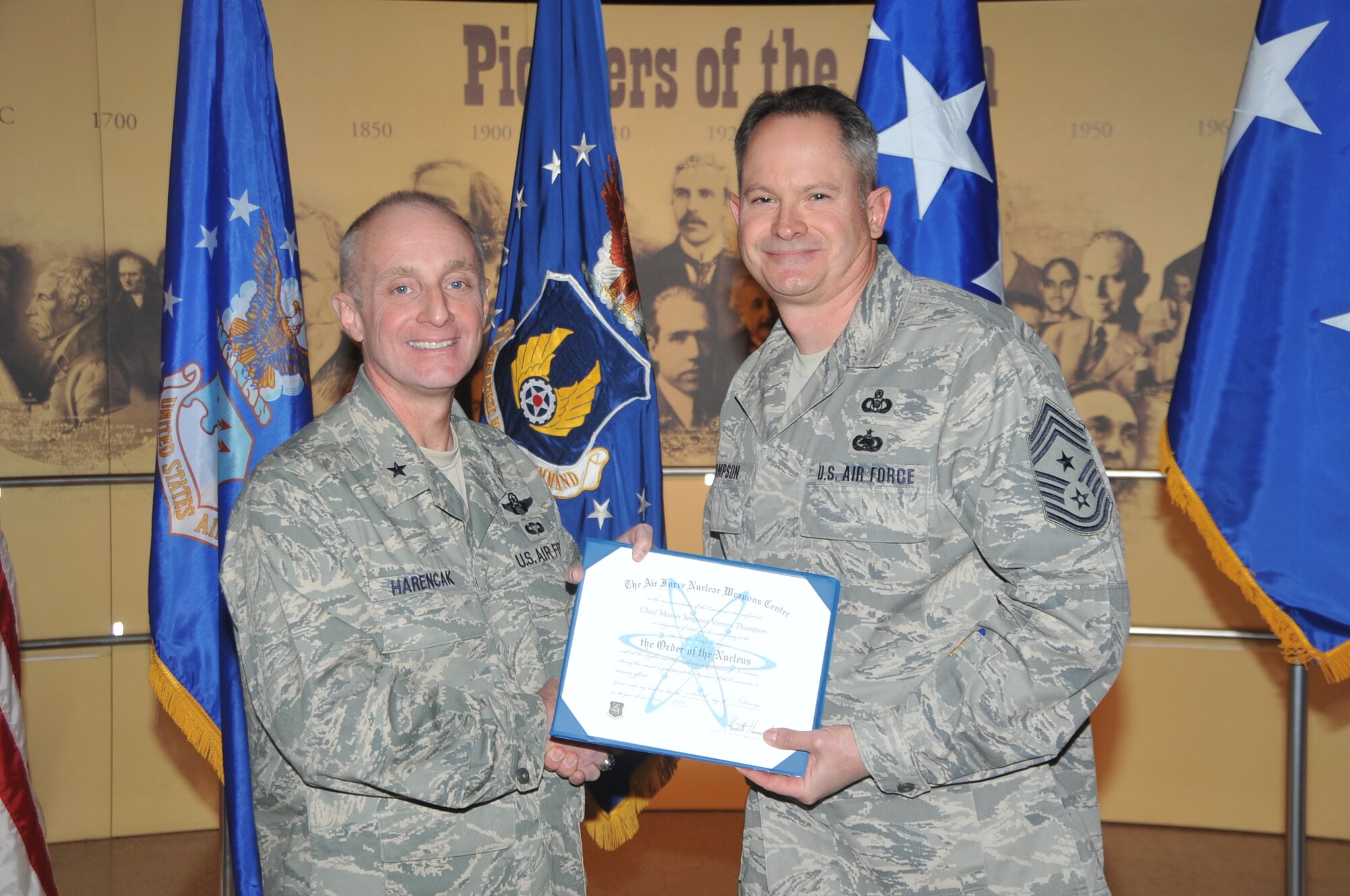 KIRTLAND AFB, N.M. -- Brig. Gen. Garrett Harencak, commander of the Air Force Nuclear Weapons Center, left, inducted Chief Master Sgt. Lee Thompson, command chief for the AFNWC and the 377th Air Base Wing, into the ‘Order of the Nucleus’ on Feb. 16 at the National Museum of Nuclear Science & History. The award is presented to those who are supporting and have supported the nuclear enterprise with great distinction. (Photo by Todd Berenger)