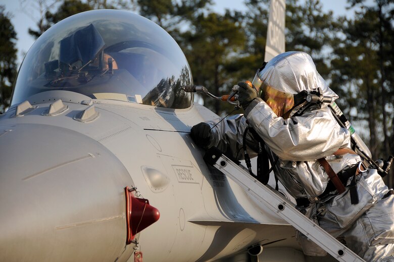 Firefighters with the 169th Civil Engineering Squadron at McEntire Joint National Guard Base, S.C., respond to a simulated aircraft mishap with a crashed F-16 fighter jet and UH-60 Black Hawk helicopter during a Crash, Damaged, Destroyed Aircraft Recovery (CDDAR) exercise on January 31, 2012.  Rescue responders attempt to extract the F-16 fighter pilot from the cockpit after arriving to the accident scene.  The training was important for all personnel involved due to the reality of the scenario, with the base sharing both air frames.
(SCANG photo by TSgt. Caycee Cook)
