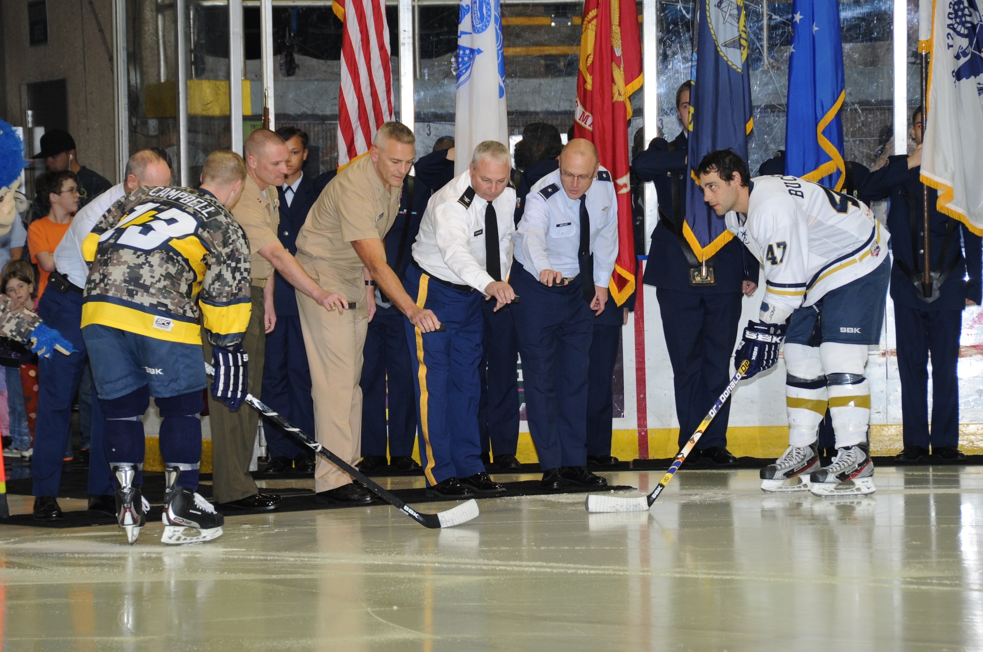 Team captains Rob Campbell, Mississippi Surge, and Dan Buccella, Pensacola Ice Flyers get ready as Warrant Officer Tom Ponte, U.S. Coast Guard Station Gulfport; Capt. Jason Burgan, Marine Corps Reserves, Gulfport Seabee Base; Capt. Stan Wiles, executive officer, Civil Engineer Corps at Gulfport Naval Construction Battalion Center; Col. Steve Parham, Camp Shelby commander; and Brig. Gen. Andrew Mueller, 81st Training Wing commander,  gather to drop the puck for the Mississippi Surge professional hockey game Feb. 18, 2012, at the Mississippi Coast Coliseum.  The Mississippi Surge honored south Mississippi’s military at Military Appreciation Night and wearing special camouflage jerseys.  (U.S. Air Force photo by Kemberly Groue)