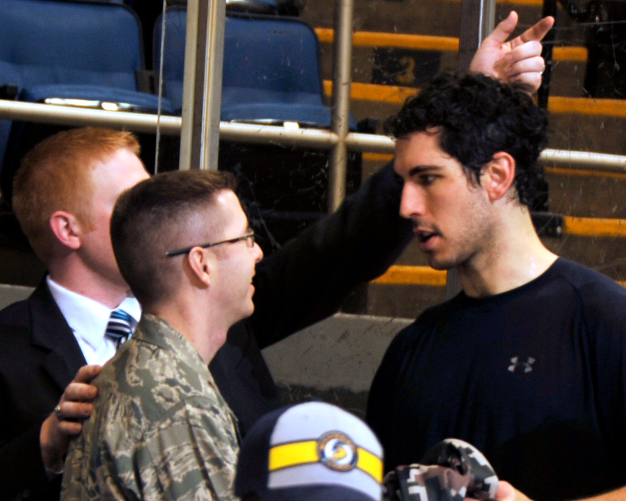 The 403rd Logistics Readiness Squadron commander, Maj. Rodney McCraine, accepts Mississippi Surge hockey player Christian Kuqali's game jersey from him during military appreciation night at the Surge hockey game Feb. 18. The 403rd Wing Recruiting Service served as a game sponsor. As a 'thank you' to the Wing, the Surge presented the jersey right off Kuqali's back at the conclusion of the third period. (U.S. Air Force photo by Maj. Heather Newcomb)