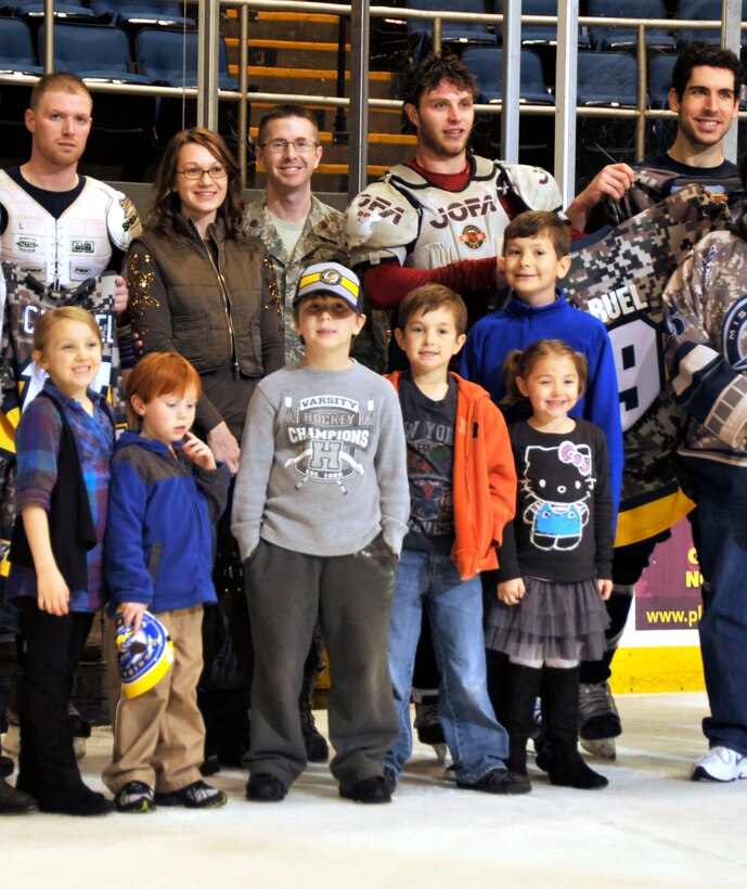 Military members and their families from along the Gulf Coast were treated to military appreciation night at the Mississippi Surge hockey game Feb. 18 when they took on the Pensacola Ice Flyers. The 403rd Wing Recruiting Service served as a game sponsor. As a 'thank you' to the Wing, the Surge presented a game jersey right off the back of one of it's players, Christian Kuqali, at the conclusion of the third period. The 403rd Logistics Readiness Squadron commander, Maj. Rodney McCraine, his family (wife Sarah, children Ethan, Jake, Katie and Emma), and Alex, son of the 403rd Wing chief of Public Affairs, accepted the jersey from Kuqali. (U.S. Air Force photo by Maj. Heather Newcomb)