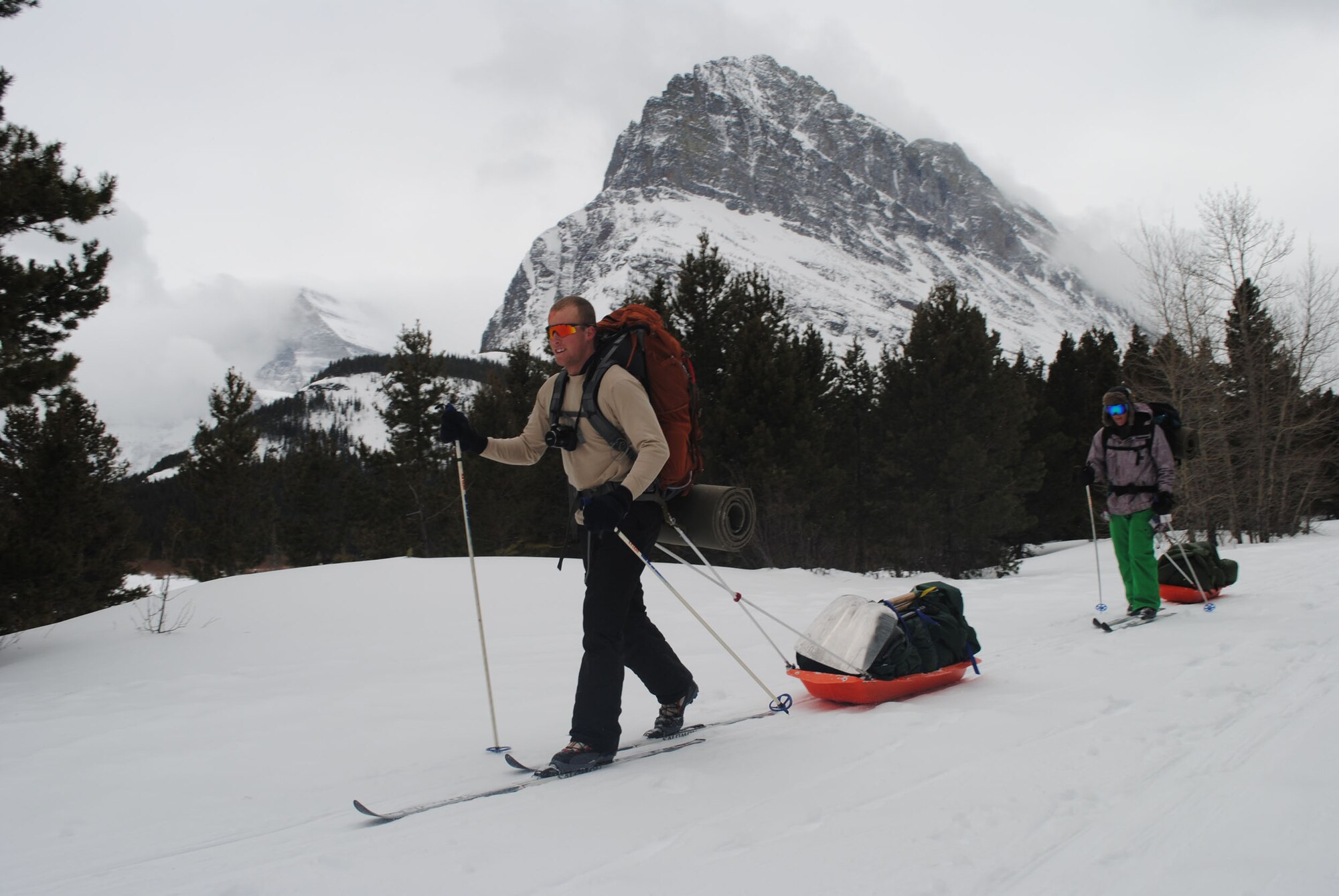 Airman 1st Class Tracy Wetzel, 819th RED HORSE Squadron pavement and equipment operator, and Airman 1st Class Dean Beckley, 819th RHS heavy equipment operator, carry tents, shovels and other equipment needed during a trip to Glacier National Park sponsored by Outdoor Recreation. The overnight camping trip to Many Glacier involved snowshoeing, cross-country skiing, and more than seven miles of sightseeing on the way to the campsite (U.S. Air Force photo/Airman 1st Class Katrina Heikkinen)
