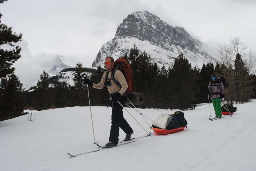 Airman 1st Class Tracy Wetzel, 819th RED HORSE Squadron pavement and equipment operator, and Airman 1st Class Dean Beckley, 819th RHS heavy equipment operator, carry tents, shovels and other equipment needed during a trip to Glacier National Park sponsored by Outdoor Recreation. The overnight camping trip to Many Glacier involved snowshoeing, cross-country skiing, and more than seven miles of sightseeing on the way to the campsite (U.S. Air Force photo/Airman 1st Class Katrina Heikkinen)
