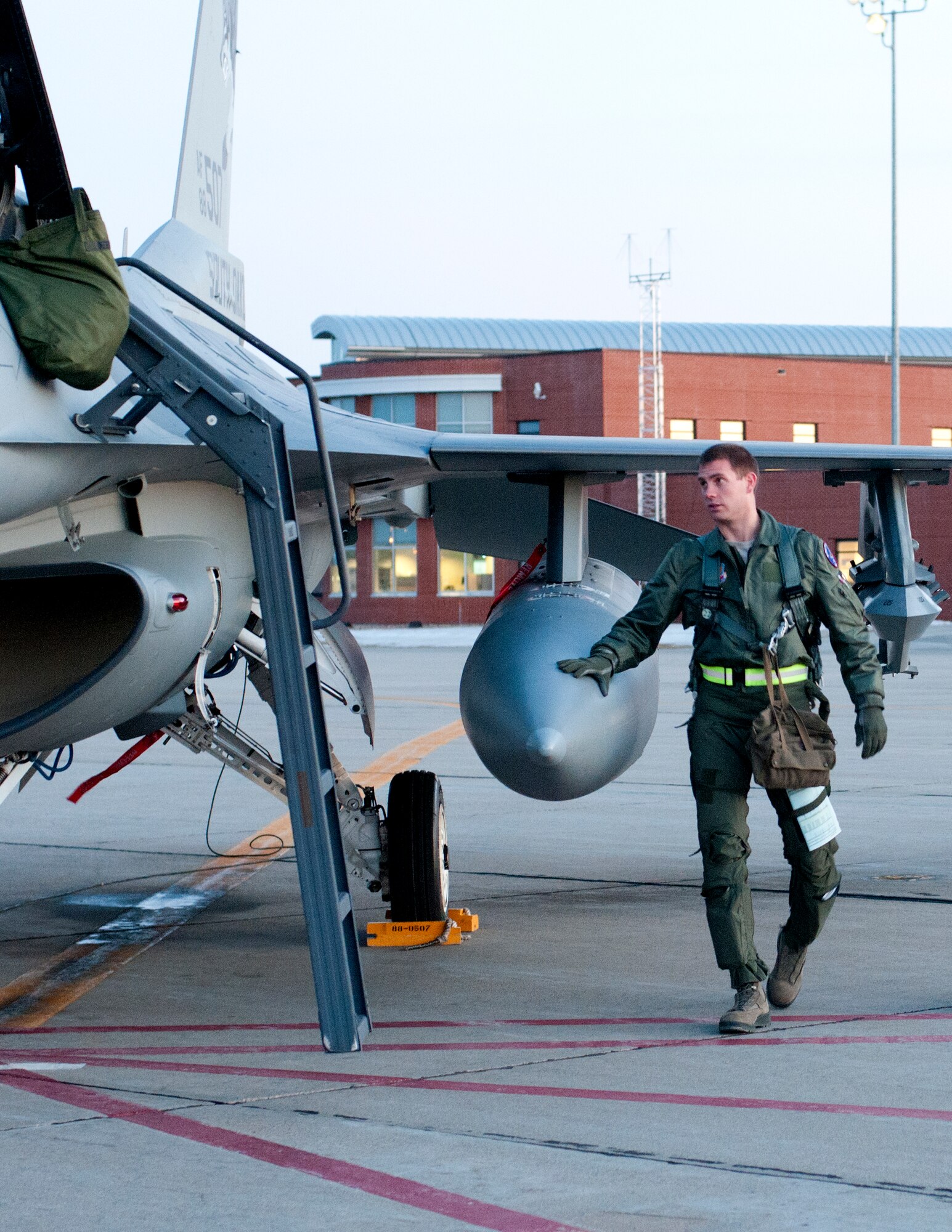 SIOUX FALLS, S.D. - As dusk sets over Joe Foss Field, S.D., 1st Lt. Aaron Werner, 175th Fighter Squadron pilot, makes his final checks on his F-16 aircraft prior to launch here Feb. 16.  The South Dakota Air National Guard does night flying about once a month for a week in order to stay proficient with nighttime operations.(National Guard photo by Senior Master Sgt. Nancy Ausland)(Released)