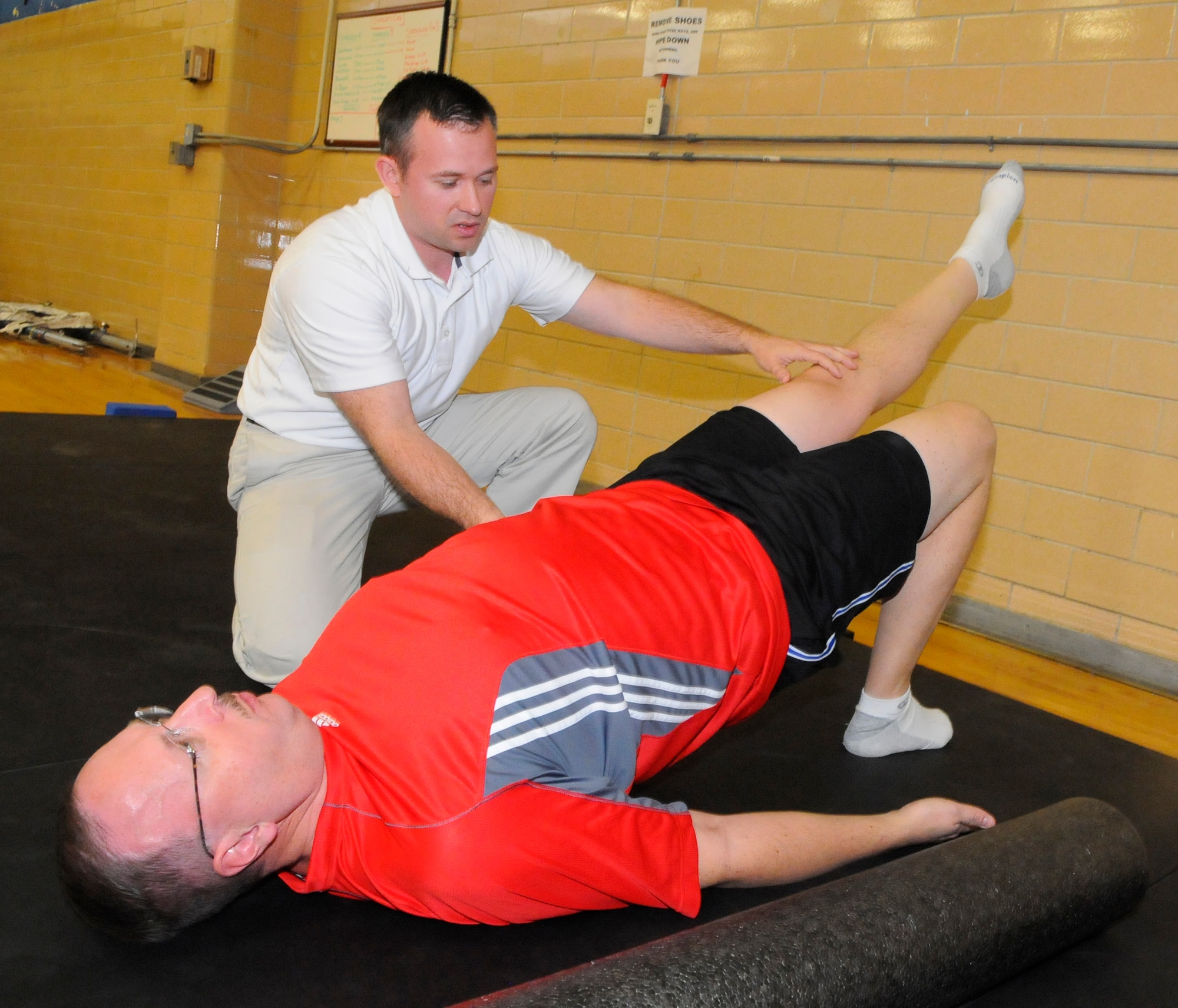 Greg Reynolds, HAWC exercise physiologist, assists Master Sgt. Bill Granger during Total Force Fitness Program corrective exercise time. (U. S. Air Force photo by Sue Sapp)