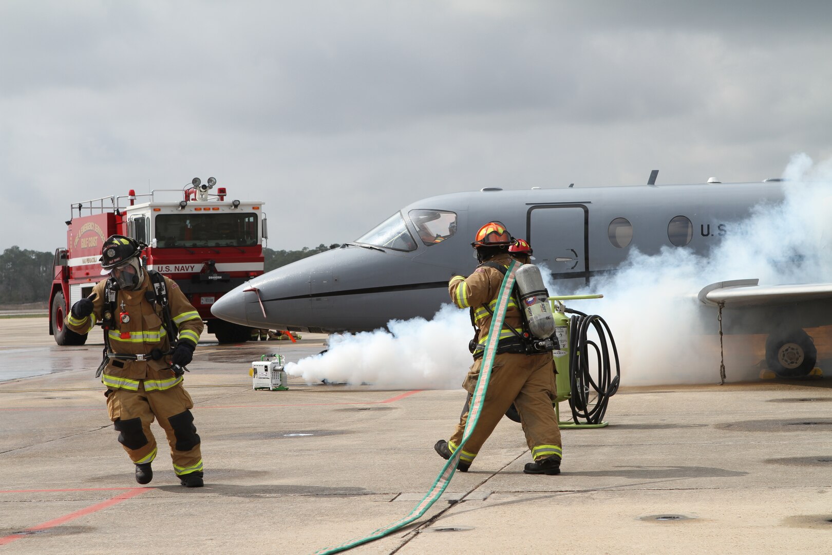 Members of the Naval Air Station Pensacola, Fla. Fire Department respond to an aircraft that had just made a simulated emergency landing as a part of the 479th Flying Training Group's aircraft mishap exercise February 16, 2012.  The exercise simulated a midair collision between a T1-A Jayhawk and T-6A Texan II and involved the 451st and 455th Flying Training Squadrons with support from the NAS Pensacola air operations, fire department and command staff. The 12th Flying Training Wing, the 479th’s parent unit, at Joint Base San Antonio-Randolph, Texas, provided off site command support for the exercise. (U.S. Air Force Photo/ 2d Lt. Kyle Arcurio