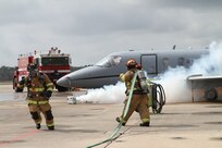 Members of the Naval Air Station Pensacola, Fla. Fire Department respond to an aircraft that had just made a simulated emergency landing as a part of the 479th Flying Training Group's aircraft mishap exercise February 16, 2012.  The exercise simulated a midair collision between a T1-A Jayhawk and T-6A Texan II and involved the 451st and 455th Flying Training Squadrons with support from the NAS Pensacola air operations, fire department and command staff. The 12th Flying Training Wing, the 479th’s parent unit, at Joint Base San Antonio-Randolph, Texas, provided off site command support for the exercise. (U.S. Air Force Photo/ 2d Lt. Kyle Arcurio