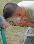 U.S. Air Force Airman 1st Class Nicholas Rasay rubs soap on his face after being pepper sprayed at Seymour Johnson Air Force Base, N.C., Feb. 17, 2012. When Pepper spray makes contact with the eyes it causes irritation, tears, pain and temporary blindness. Rasay, 4th Security Forces Squadron augmentee and 4th Aircraft Maintenance Squadron avionics apprentice, hails from Douglasville, Ga. (U.S. Air Force photo/Senior Airman Gino Reyes/Released)