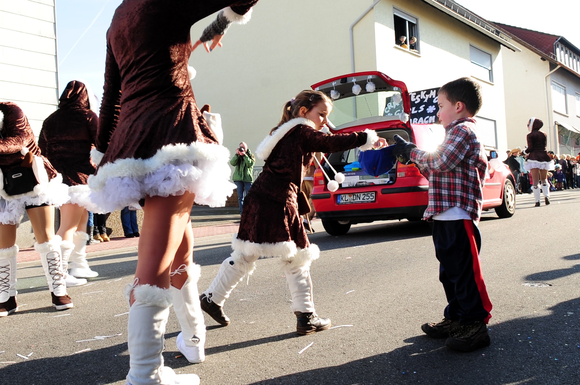 A parade participant hands out candy to a crowd member during the annual celebration of Fasching parade, Ramstein Village, Germany, Feb. 21, 2012. This annual event is a pre-Lenten carnival which is celebrated with the donning of wild and fancy costumes to chase away the evil spirits of winter in preparation for spring. (U.S. Air Force photo by Senior Airman Brittany Perry)