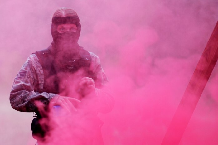 Staff Sgt. Christina Andros looks for a target through the smoke during a "Shoot, Move, Communicate" training course at Joint Base Charleston - Air Base Feb. 16. The training teaches Airmen to react to a hostile shooter by using cover and effective communication to maneuver and engage the target. Andros is a 628th Security Forces Squadron patrolman.  (U.S. Air Force photo/ Staff Sgt. Nicole Mickle)  