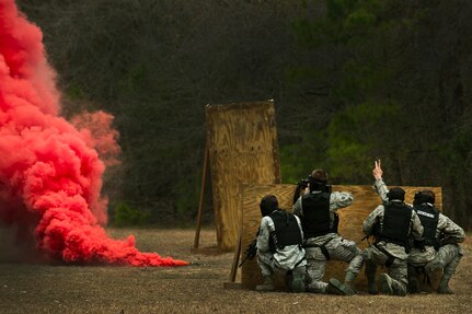 Airmen take cover behind a wall during a “Shoot, Move, Communicate” training course  at the Combat Arms Training and Maintenance range at Joint Base Charleston - Air Base Feb. 16. The training teaches Airmen to react to a hostile shooter by using cover and effective communication to maneuver and engage the target. (U.S. Air Force photo by Airman 1st Class George Goslin)