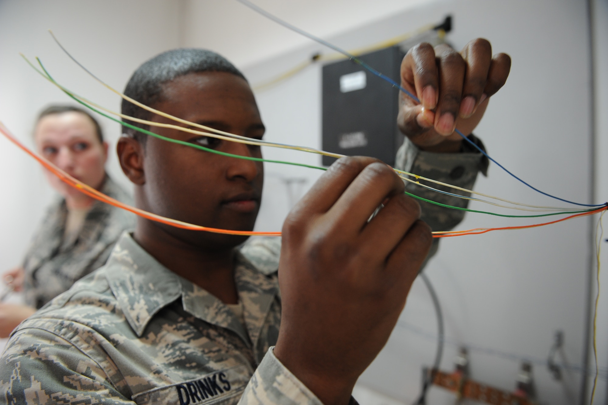 SOUTHWEST ASIA – Airman 1st Class Baron Drinks, 379th Expeditionary Communications Squadron cable technician and native of Brooklyn, N.Y., separates wires from each other prior to a new data line installation here Feb. 18, 2012. Cable technicians are trained are trained to install and repairs many kinds of wire systems, including copper, optical fiber, and local area network cables. (U.S. Air Force photo/Staff Sgt. Nathanael Callon)