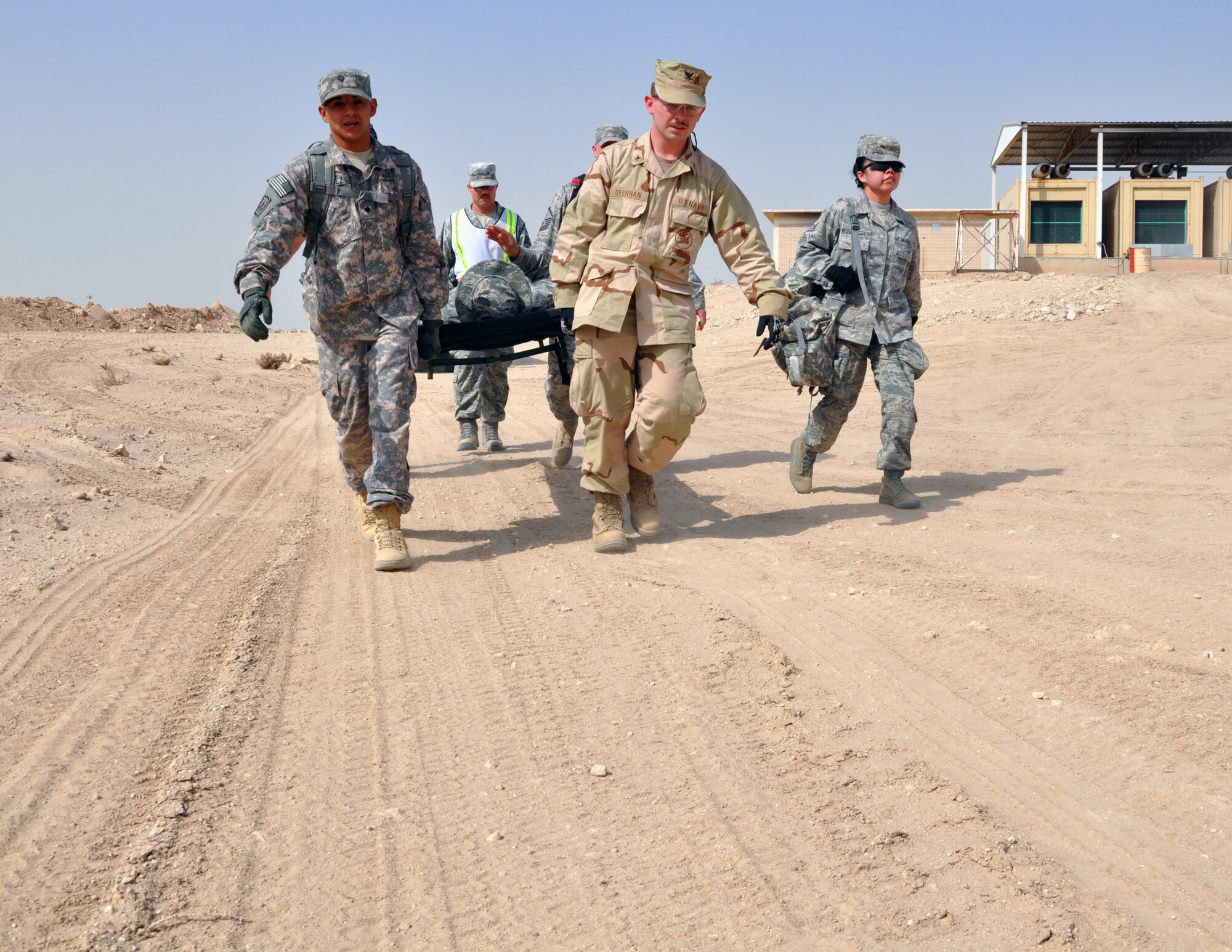 U.S. Air Force, Army and Navy medics and firefighters carry a litter with a simulated patient as part of an EMT Rodeo hosted by the 386th Expeditionary Medical Group in an undisclosed location, Southwest Asia, Feb. 18, 2012.  These emergency medical technicians participated in the competition to test their skills and knowledge in responding to different emergency situations alongside military and civilian EMT personnel from the Air Force, Army, and Navy. (U.S. Air Force photo/Tech. Sgt. Stacy Fowler)