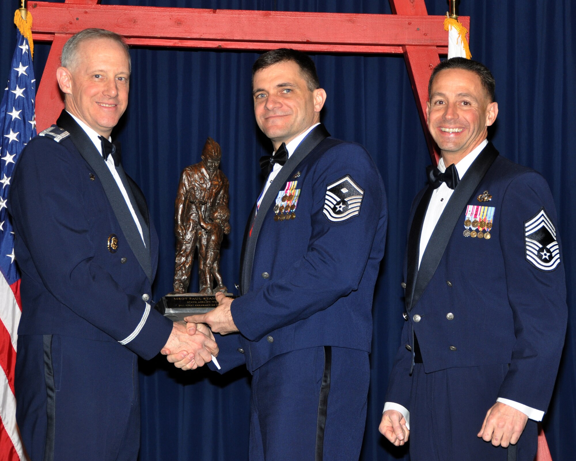YOKOTA AIR BASE, Japan -- Col. Otto Feather, 374th Airlift Wing commander, and Chief Master Sgt. Richard Redman, acting 374th AW command chief master sergeant, presents Master Sgt. Paul Stansbury, center, with the First Sergeant of the Year award at Yokota Air Base, Japan, Feb. 17, 2012. Stansbury is assigned to the 374th Logistics Readiness Squadron. (U.S. Air Force photo /Airman 1st Class Katrina R. Menchaca)