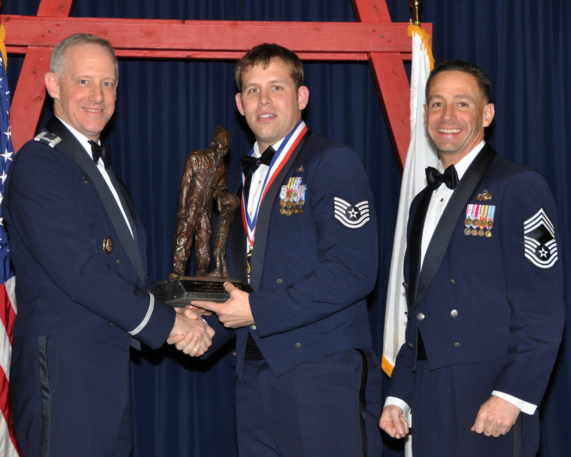 YOKOTA AIR BASE, Japan -- Col. Otto Feather, 374th Airlift Wing commander, and Chief Master Sgt. Richard Redman, acting 374th AW command chief master sergeant, presents Tech. Sgt. Jason Harper, center, with the Kensei Noncommissioned Officer award at Yokota Air Base, Japan, Feb. 17, 2012. Harper is assigned to 5th Air Force. (U.S. Air Force photo /Airman 1st Class Katrina R. Menchaca)