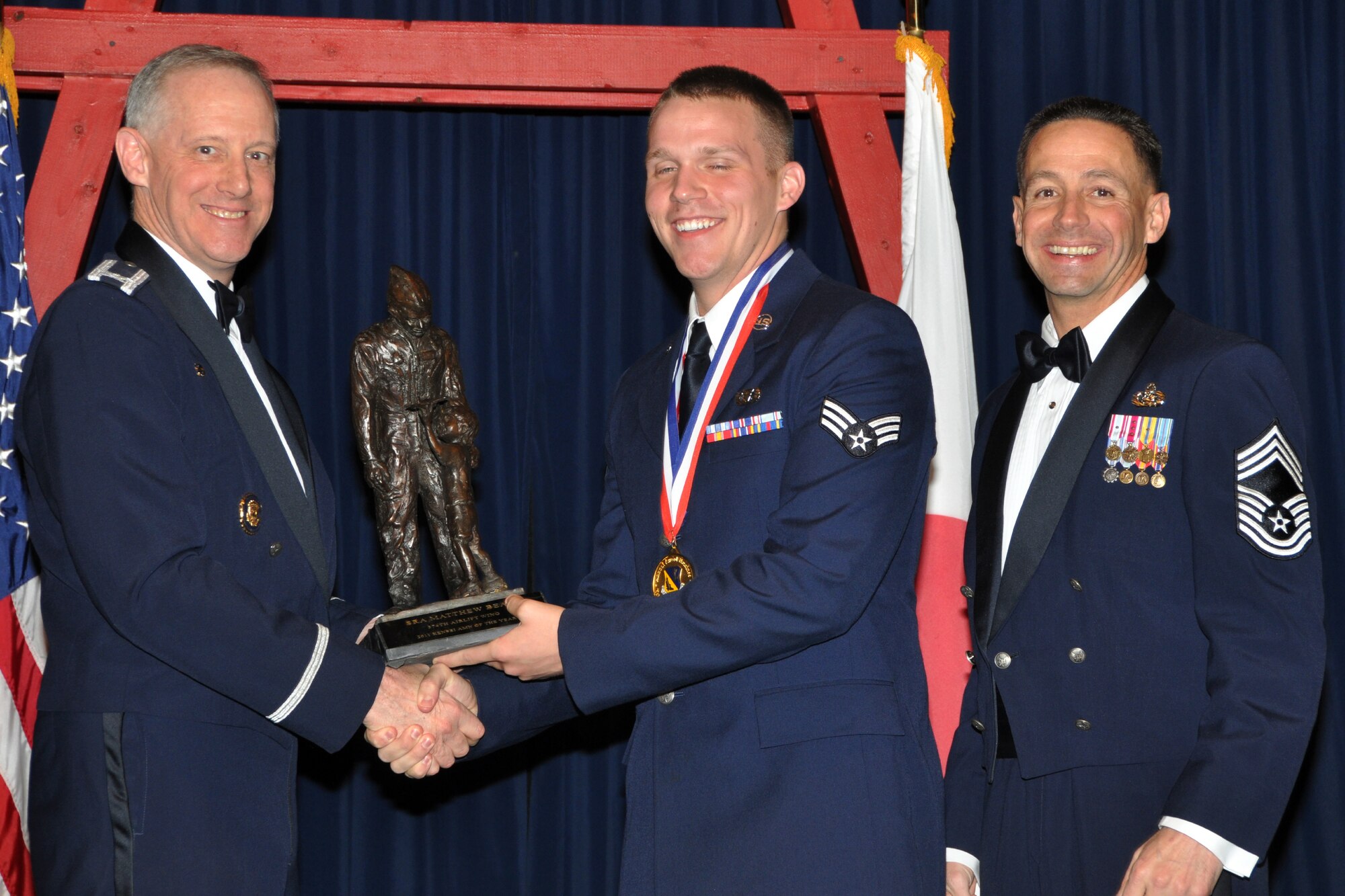 YOKOTA AIR BASE, Japan -- Col. Otto Feather, 374th Airlift Wing commander, and Chief Master Sgt. Richard Redman, acting 374th AW command chief master sergeant, presents Senior Airman Matthew Bean, center, with the Kensei Junior Enlisted Airman award at Yokota Air Base, Japan, Feb. 17, 2012. Bean is assigned to the 730th Air Mobility Squadron. (U.S. Air Force photo /Airman 1st Class Katrina R. Menchaca)