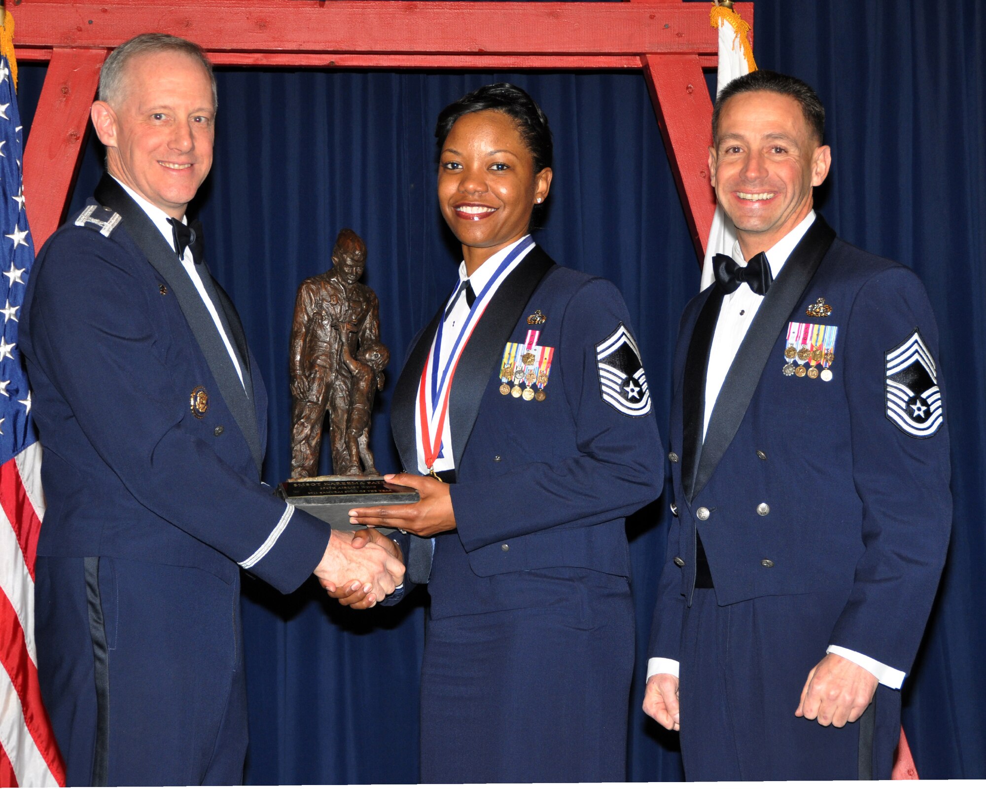 YOKOTA AIR BASE, Japan -- Col. Otto Feather, 374th Airlift Wing commander, and Chief Master Sgt. Richard Redman, acting 374th AW command chief master sergeant, presents Senior Master Sgt. Kareema Patton, center, with the Samurai Senior Noncommissioned Officer award at Yokota Air Base, Japan, Feb. 17, 2012. Patton is assigned to 374th Communications Squadron. (U.S. Air Force photo /Airman 1st Class Katrina R. Menchaca)