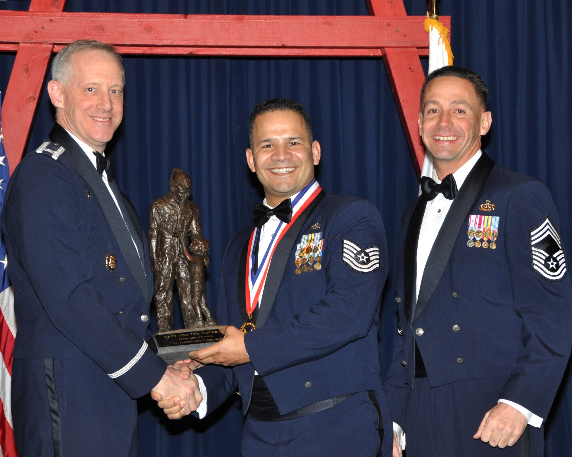YOKOTA AIR BASE, Japan -- Col. Otto Feather, 374th Airlift Wing commander, and Chief Master Sgt. Richard Redman, acting 374th AW command chief master sergeant, presents Tech. Sgt. Mentor Cavazos, center, with the Samurai Noncommissioned Officer award at Yokota Air Base, Japan, Feb. 17, 2012. Cavazos is assigned to the 374th Communications Squadron. (U.S. Air Force photo /Airman 1st Class Katrina R. Menchaca)