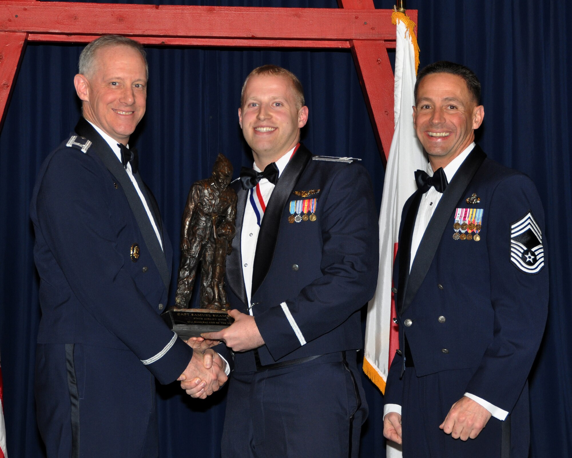 YOKOTA AIR BASE, Japan -- YOKOTA AIR BASE, Japan -- Col. Otto Feather, 374th Airlift Wing commander, and Chief Master Sgt. Richard Redman, acting 374th AW command chief master sergeant, presents Capt. Samuel Shamburg, center, with the Samurai Company Grade Officer award at Yokota Air Base, Japan, Feb. 17, 2012. Shamburg is assigned to the 459th Airlift Squadron. (U.S. Air Force photo /Airman 1st Class Katrina R. Menchaca)