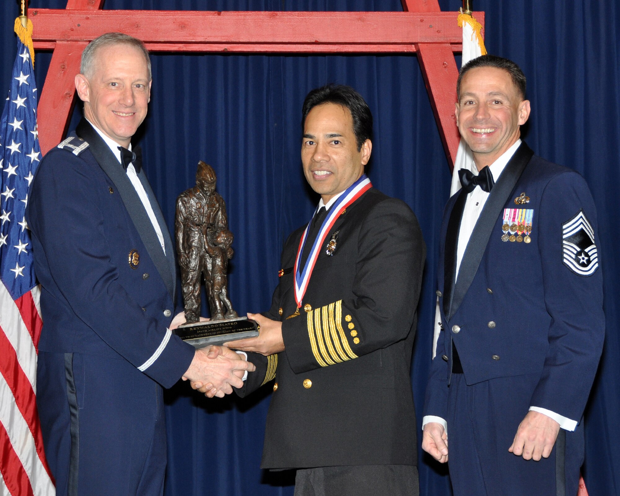 YOKOTA AIR BASE, Japan -- Col. Otto Feather, 374th Airlift Wing commander, and Chief Master Sgt. Richard Redman, acting 374th AW command chief master sergeant, presents Reynold Mateo, center, with the Team Yokota Category III Civilian award at Yokota Air Base, Japan, Feb. 17, 2012. Mr. Mateo is assigned to the 374th Civil Engineer Squadron. (U.S. Air Force photo /Airman 1st Class Katrina R. Menchaca)