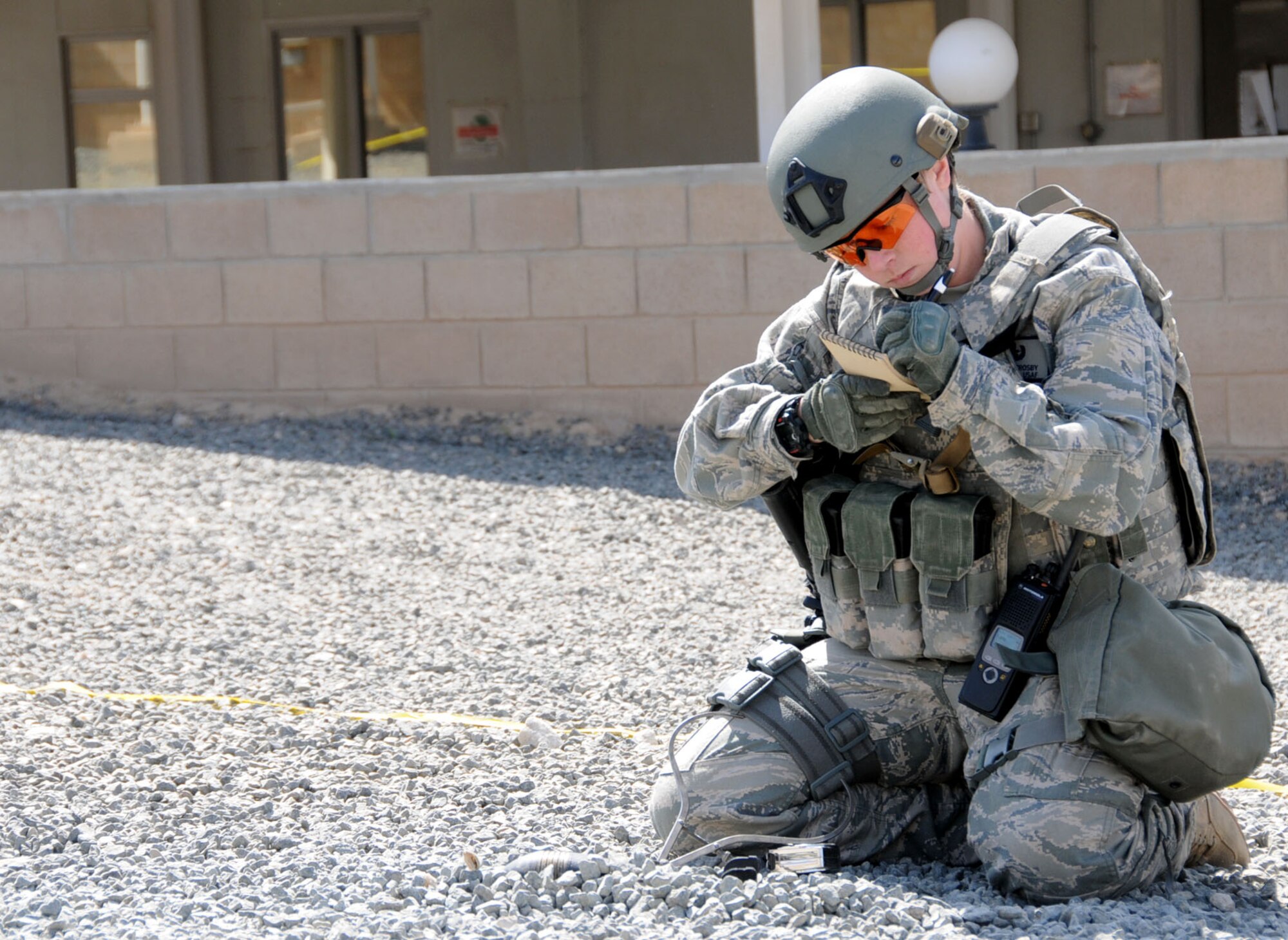 U.S. Air Force Airman 1st Class Katelyn Crosby, 386th Expeditionary Civil Engineering Squadron explosive ordnance technician, writes down a description of simulated unexploded ordnance (UXO) in an undisclosed location in Southwest Asia, Feb. 21, 2012. Crosby, deployed from the 31st CES, Aviano Air Base, Italy, wrote a description of the UXO during a "bunker dive" exercise used to evaluate the overall readiness of base personnel and facilities while under a simulated attack. (U.S. Air Force photo by Staff Sgt. James Lieth/Released)