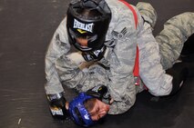 Senior Airman Sheena Thompson puts her opponent Senior Airman Lizette Zambrano, both 51st Security Forces Squadron members, into a submissive position during the combatives portion of a Combat Readiness Course here, Feb. 21, 2012. Airmen are awarded points for establishing good fighting habits and for emphasizing the importance of dominant body positions. (U.S. Air Force photo/Staff Sgt Craig Cisek)