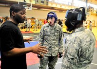 (Left) Senior Airman Antonio Johnson, 51st Security Forces Squadron combat readiness course instructor, speaks with both  Airman 1st Class Joseph Bird and Allen Perry, both 51st Security Forces Squadron members, during the combatives portion of a Combat Readiness Course here, Feb. 21, 2012. Airmen had eight different ways to score points that range from  take downs from the standing position, take downs from the seated position, passing the guard, sweeping, knee in the chest, reversal of submission, mounting and back mounting. (U.S. Air Force photo/Senior Airman Adam Grant)
