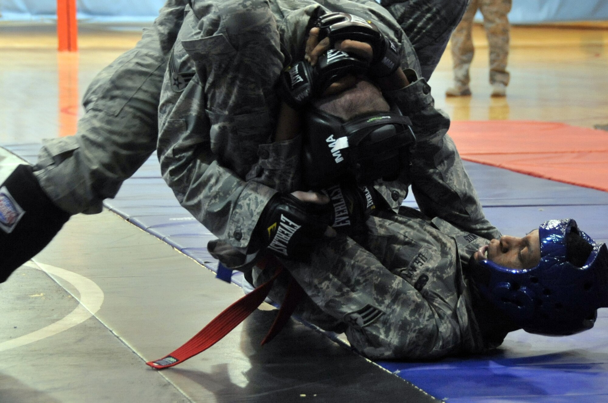 Senior Airman RaNee Woods, 51st Security Forces Squadron member, attempts to wrap up his opponent on the mat during the combatives portion of a Combat Readiness Course here, Feb. 21, 2012. Airmen are awarded points for good fighting habits and for emphasizing the importance of dominant body positions. (U.S. Air Force photo/Staff Sgt Craig Cisek) 