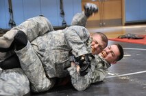 Staff Sgt. Curtis Cain swings at his opponent Staff Sgt. Justin Clark, both 51st Security Forces Squadron members, during the combative portion of a Combat Readiness Course here, Feb. 21, 2012. The combatives portion of the CRC tests the Airmen’s abilities to defend themselves when placed in threatening situations. (U.S. Air Force photo/Staff Sgt Craig Cisek)