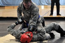 Airman 1st Class Adam Shipley, 51st Security Forces Squadron member, pins down his opponent Senior Airman Joshua Davies, 51st Security Forces Squadron member, during the combative portion of a Combat Readiness Course here, Feb. 21, 2012. The combative portion of the CRC tests the Airmen’s abilities to defend themselves when placed in threatening situations. (U.S. Air Force photo/Staff Sgt Craig Cisek)