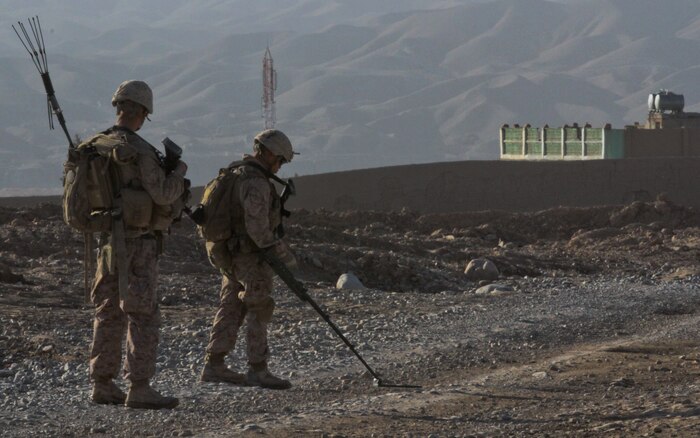 Lance Cpl. Edgar Lima (right), a sweeper with 2nd squad, 1st platoon, Lima Company, searches for improvised explosive devices with PFC. Christopher Birdt, a machine gunner, covering him, during an afternoon patrol in Wishtan, Feb. 22. Their patrol talked to as many local people as they could, gathering information about the area and building relationships with the people. Lima, a San Diego native, uses humor to interact and build connections with the children who sometimes surround the Marines.