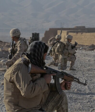 An Afghan National Civil Order Policeman with 1st Tolai, 4th Kandak, 3rd Brigade, posts security near the town of Wishtan, with the Marines of 2nd Squad, 1st Platoon, Lima Company, Feb. 22. The squad, part of 3rd Battalion, 7th Marine Regiment, patrolled parts of Wishtan and asked local people questions about the area. The Marines always patrol with atleast one ANCOP.