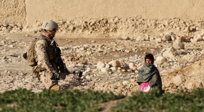 Lance Cpl. Edgar Lima, a sweeper with 2nd Squad, 1st Platoon, Lima Company, approaches a curious Afghan child, while on patrol in Wishtan, Feb. 22. Lima, currently deployed with 3rd Battalion, 7th Marine Regiment, made funny faces in a playful game with the children. Lima said using humor is a good way to prevent being seen as ‘faceless’ and builds positive relations with the local people.
