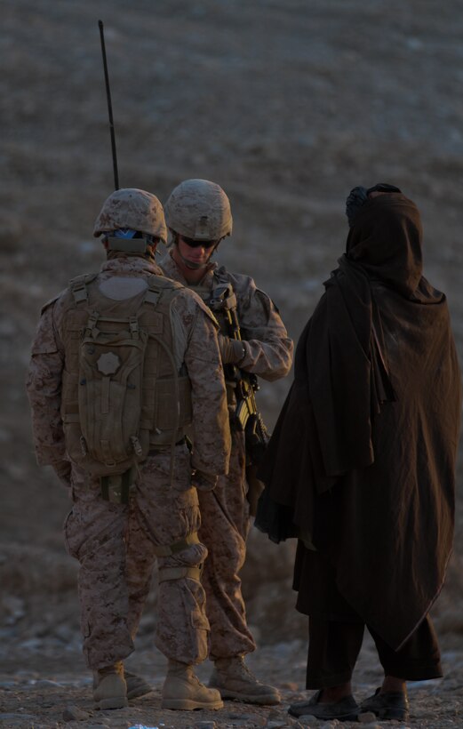 Corporal David Wood, a squad leader with 1st Platoon, Lima Company, 3rd Battalion, 7th Marine Regiment, talks, with the help of his interpreter, to local Afghans during a patrol, Feb. 22. Wood, a native of San Bernardino, Calif., stopped and talked to as many local people as he could, building positive relationships in the area. The patrol left early in the afternoon and Afghan children greeted the Marines along their way.