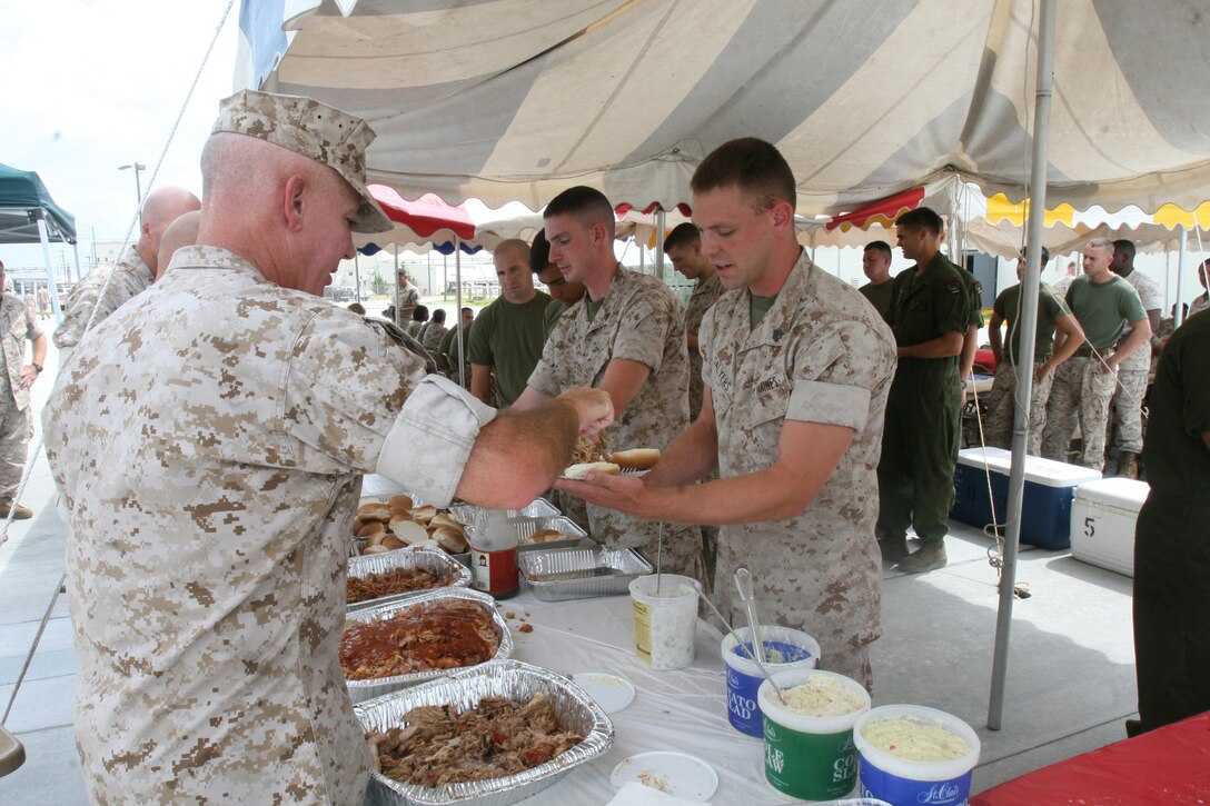 Lt. Col. Hugh R. Ware, Marine Aviation Logistics Group 29 commanding officer, serves pulled pork to Sgt. Shane A. Salyers, MALS-29 flight equipment technician. MALS-29 held a Marine Appreciation event outside their hangar to boost morale and camaraderie, Aug. 18.