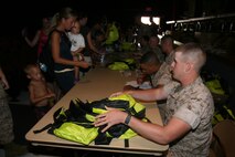 Pfc. Matt S. Fryer prepares backpacks to hand out to participants of Kid's Day event. Marine Corps Air Station New River hosted a Kid's Day in the station theater parking lot to prepare children to go back to school, Aug. 16.