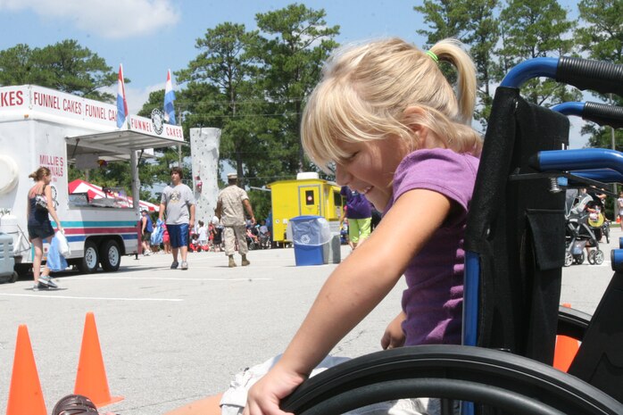 Allie J. Pider participates in a wheelchair course during Marine Corps Air Station New River's Kid's Day event in the station theater parking lot to prepare children to go back to school, Aug. 16.