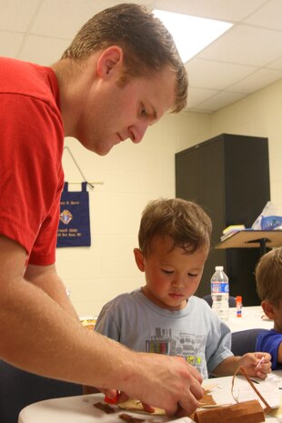 Charles Wofford and his son, Tyler work on a project following a reading of "Where the Wild Things Are." Marine Corps Air Station New River hosted a Kid's Day in the station theater parking lot to prepare children to go back to school, Aug. 16.