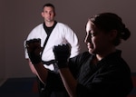 Natalie Incrocci puts up a fighting stance as Jim Fiore, women’s self defense instructor, observes her performance Feb. 6 at the Chaparral Fitness Center. (U.S. Air Force photo/Robbin Cresswell)