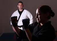 Natalie Incrocci puts up a fighting stance as Jim Fiore, women’s self defense instructor, observes her performance Feb. 6 at the Chaparral Fitness Center. (U.S. Air Force photo/Robbin Cresswell)