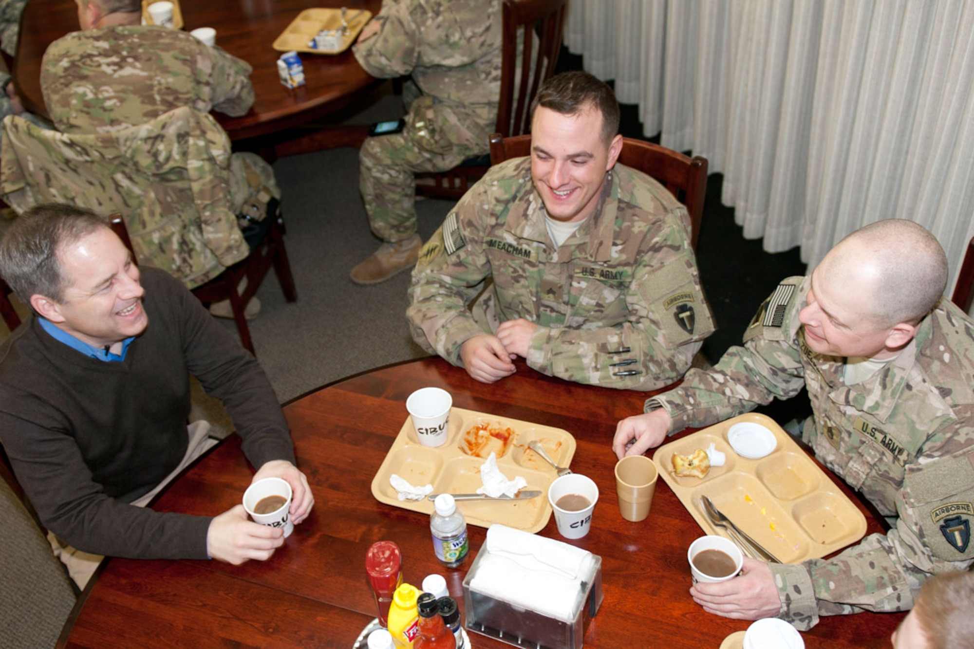 Alaska Gov. Sean Parnell visits with National Guardsmen Sgt. Joseph Meacham, center, of Anchorage, and Staff Sgt. James Zuelow, of Juneau, both of B Company, 1st Battalion (Airborne), 143rd Infantry Regiment, at the King Dining Facility on Camp Atterbury, Ind., Feb. 16.  (U.S. Army photo/Staff Sgt. Karima Turner)
