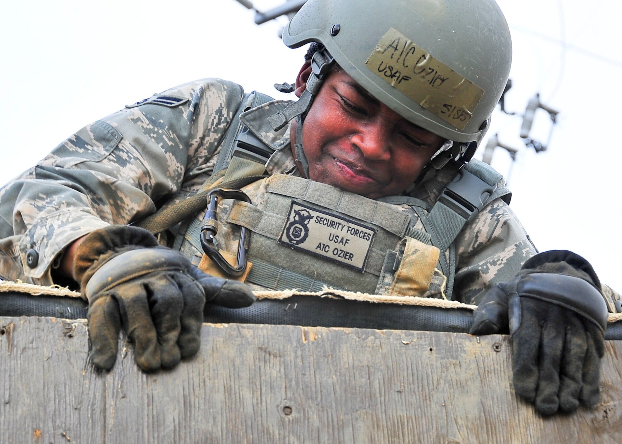 Airman 1st Class BreAuna Ozier, 51st Security Forces Squadron member, attempts to climb an 8-foot wall during the confidence course portion of the Combat Readiness Course here, Feb. 23, 2012. During the course, members answer knowledge questions, perform sprints, roll tires, low crawl for 30 yards, maneuver over and 8-foot wall, litter carry and injured team member for 400 meters and compete in a weapons challenge. (U.S. Air Force photo/Senior Airman Adam Grant)