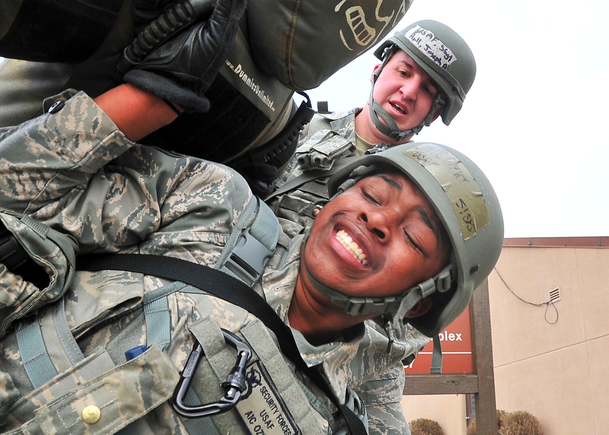 Airman 1st Class BreAuna Ozier, 51st Security Forces Squadron member, attempts to place a training mannequin over her shoulders while Staff Sgt. Joseph Hall, 51st Security Forces Squadron member, assists during the confidence course portion of the Combat Readiness Course here, Feb. 23, 2012. The CRC happens once a month and is offered to all new security forces members. (U.S. Air Force photo/Senior Airman Adam Grant)