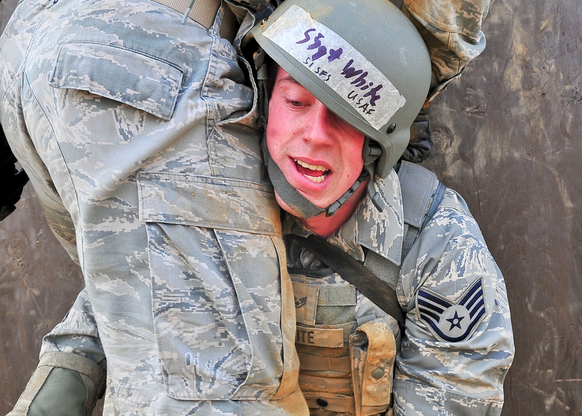 Staff Sgt. Nicholas White, 51st Security Forces Squadron member, helps a teammate cross the 8-foot wall during the confidence course portion of the Combat Readiness Course here, Feb. 23, 2012. The confidence course tests the participants’ ability to survive as a team while communicating   when placed in stressful situations. (U.S. Air Force photo/Senior Airman Adam Grant)